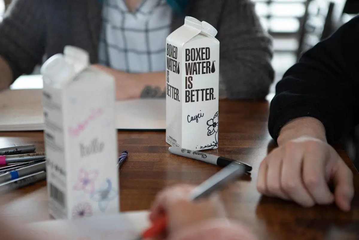 Boxed Water's packaging uses less ink with its black and white design and features eco-friendly materials for conscious consumers.