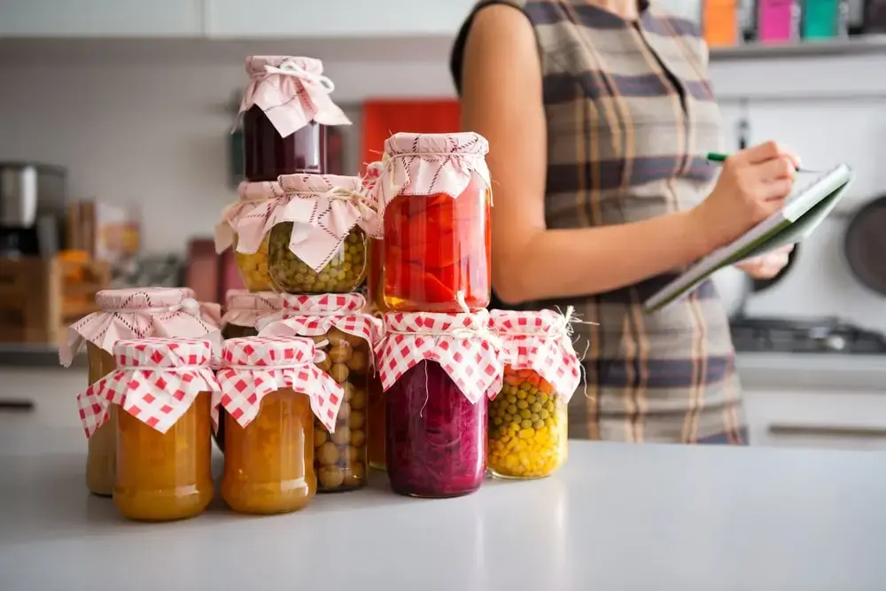 Shows someone taking inventory of their produced canned products - a viable business idea.