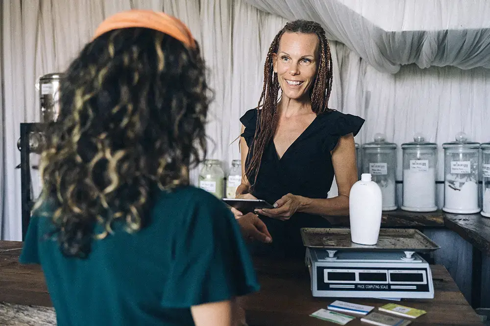 Shows a salesclerk asking a customer questions about her shopping experience.