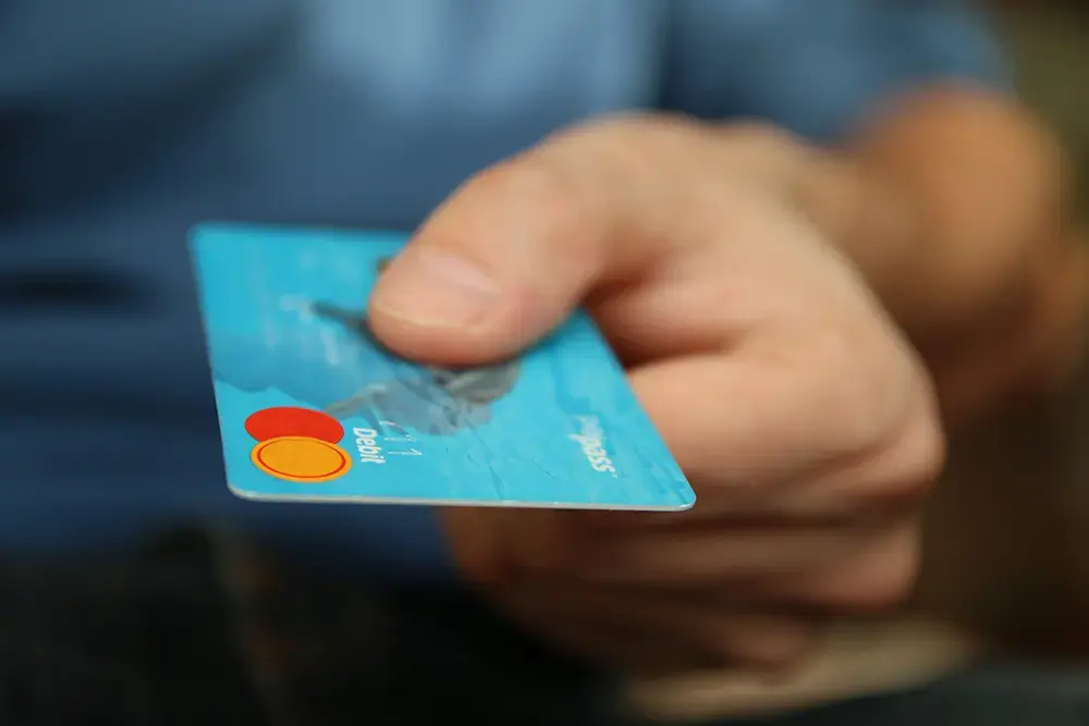 A close-up of a customer handing over their credit card, trusting the brand they're purchasing from.