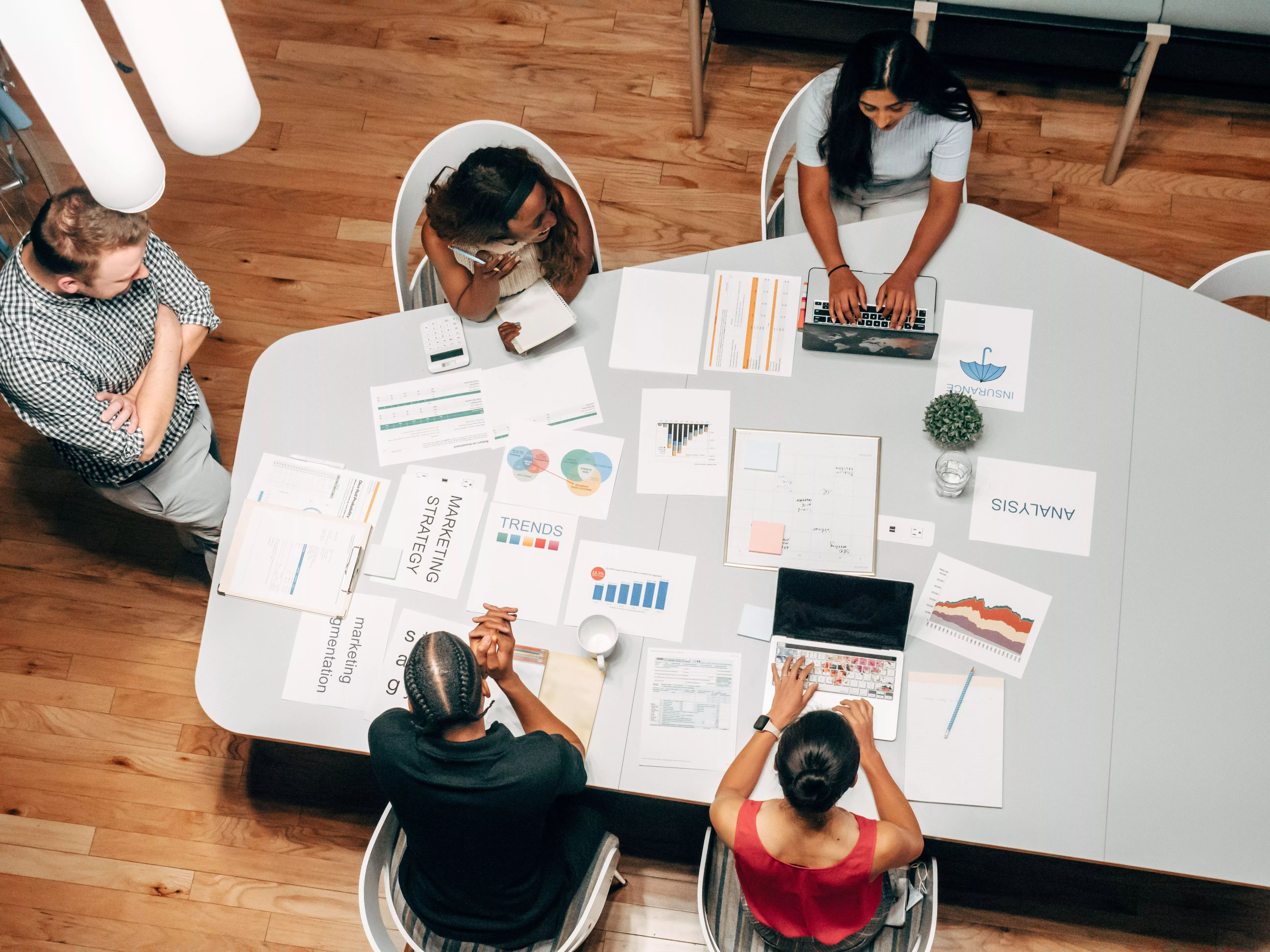 Shows a team at a table looking at eCommerce trends and data.