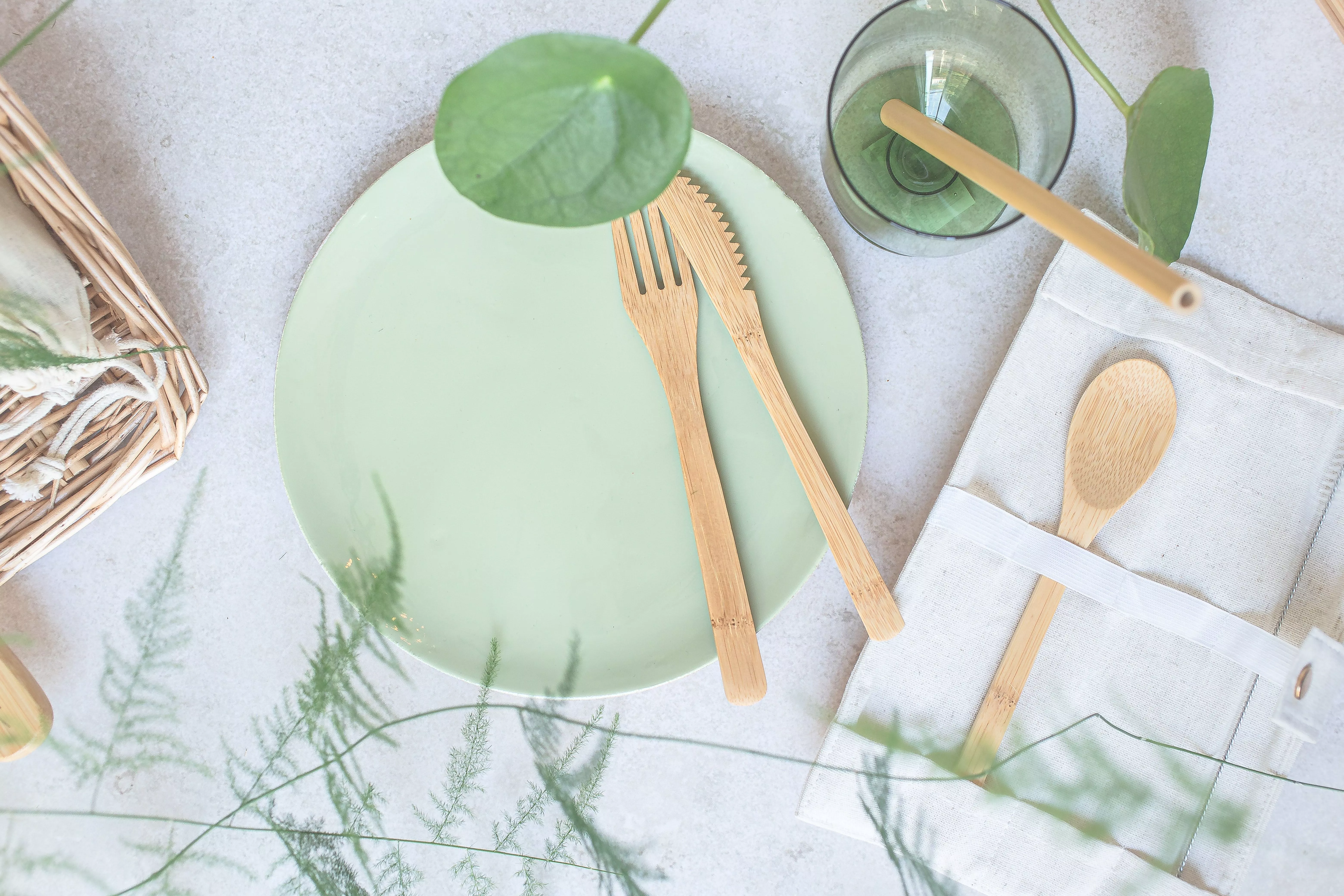 Features a flat lay of sustainable cutlery, straws, napkins, and plates adopted by eCommerce businesses.