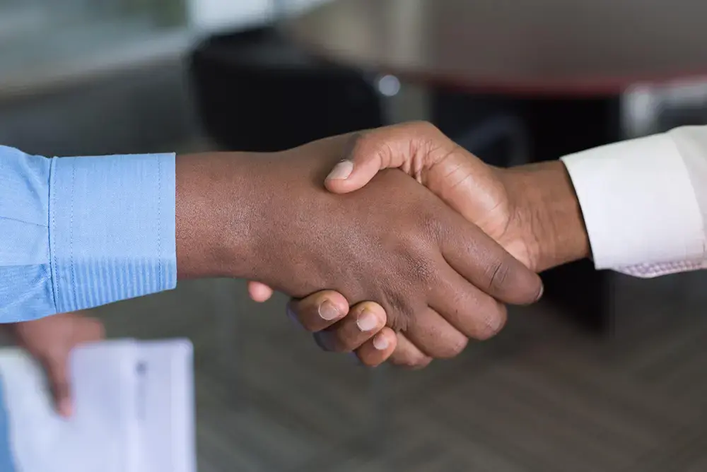 Close-up of a handshake, symbolizing a strengthened bond between a brand and their customer.