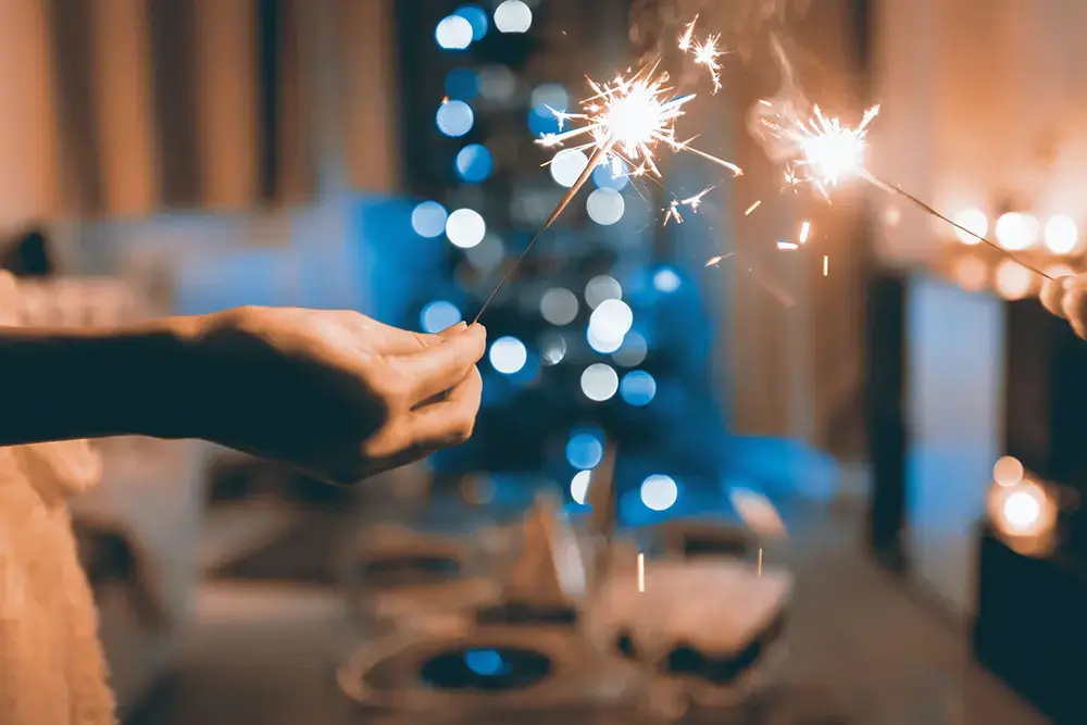 Shows two people with sparklers, highlighting a festive activity marketers can leverage in holiday campaigns.