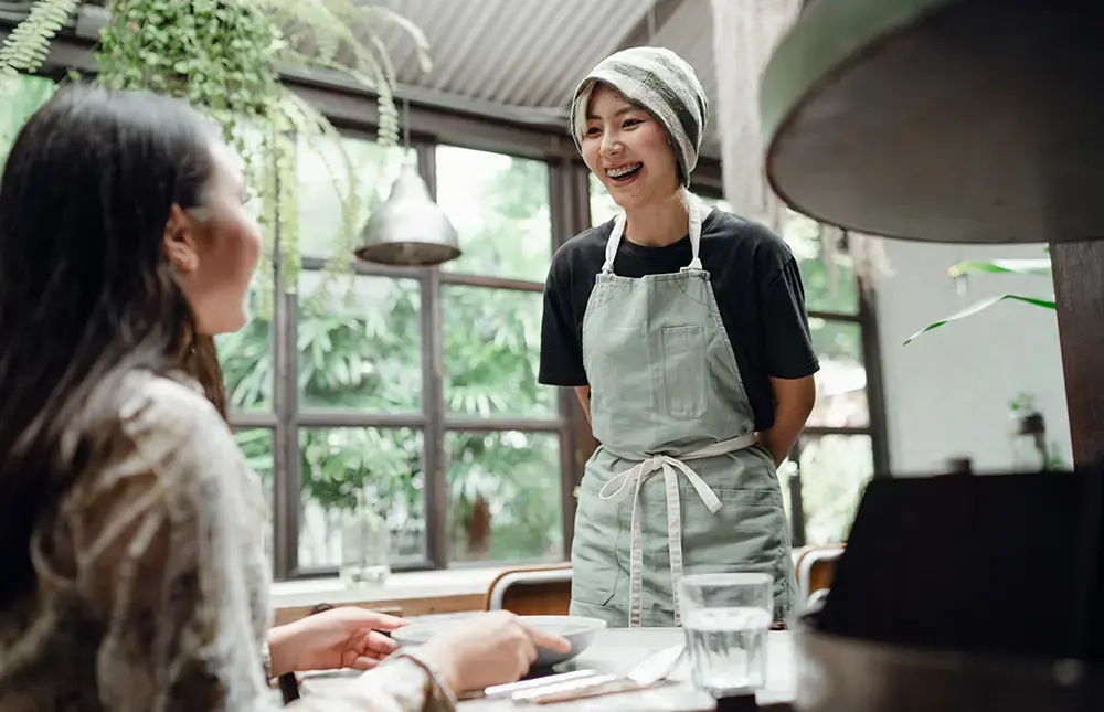 Shows staff engaging positively with cafe customers, demonstrating how great experiences build relationships with valuable customers.