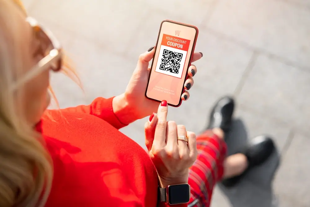 A customer viewing a discount coupon on her phone from a loyalty program.