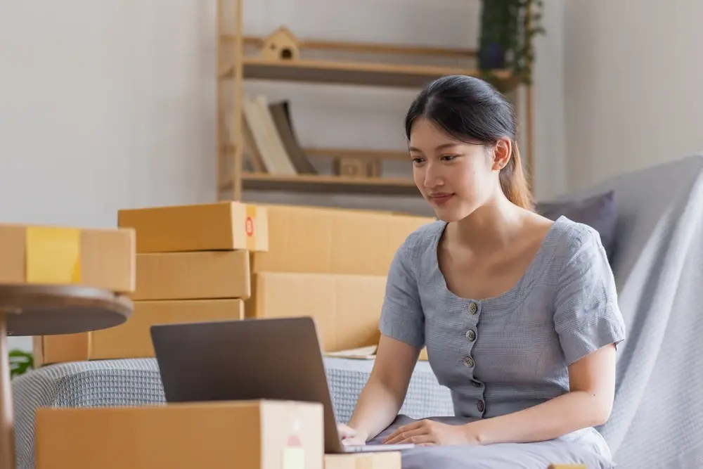 Shows a woman registering her online business on her laptop, planning to launch with a RUSH eStore platform.