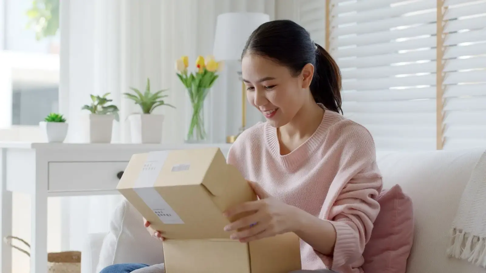 A woman looking at a package that was delivered to her by an eCommerce business.