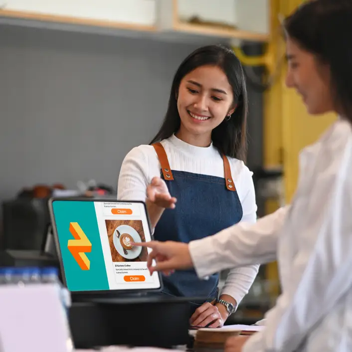 Shows a cafe owner letting their customers use the RUSH eStore to place their order.