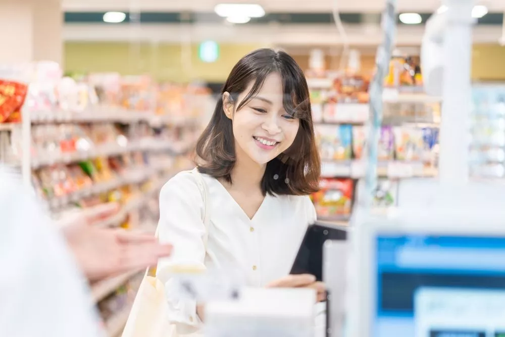 A customer uses their loyalty card at checkout in a Philippine grocery, highlighting the importance of loyalty programs for customer retention.