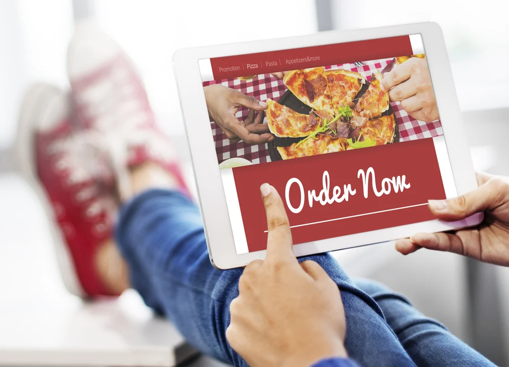 A person taps an Order Now banner, emphasizing the value of online promotions for food businesses.