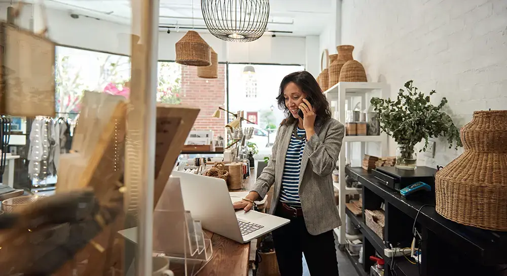 Shows a business owner at the counter, managing daily operations of her new retail business.