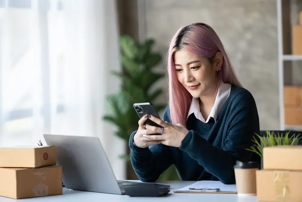 Features a woman going through eCommerce sites in the Philippines on her phone.